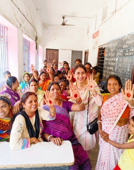 Women at an SCCF cancer awareness session in Bihar, raising their hands during a self-examination demonstration